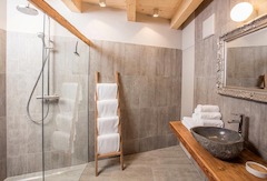 Modernes Badezimmer mit Regendusche in den Chalets von Alpegg in Waidring, Tirol.