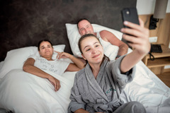 Familie macht Selfie im Bett Hotel das GXUND