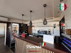 Der Theken- und Barbereich von Nonna’s Pizzeria mit Kaffeemaschine, Getränkeauswahl und moderner Holzverkleidung.